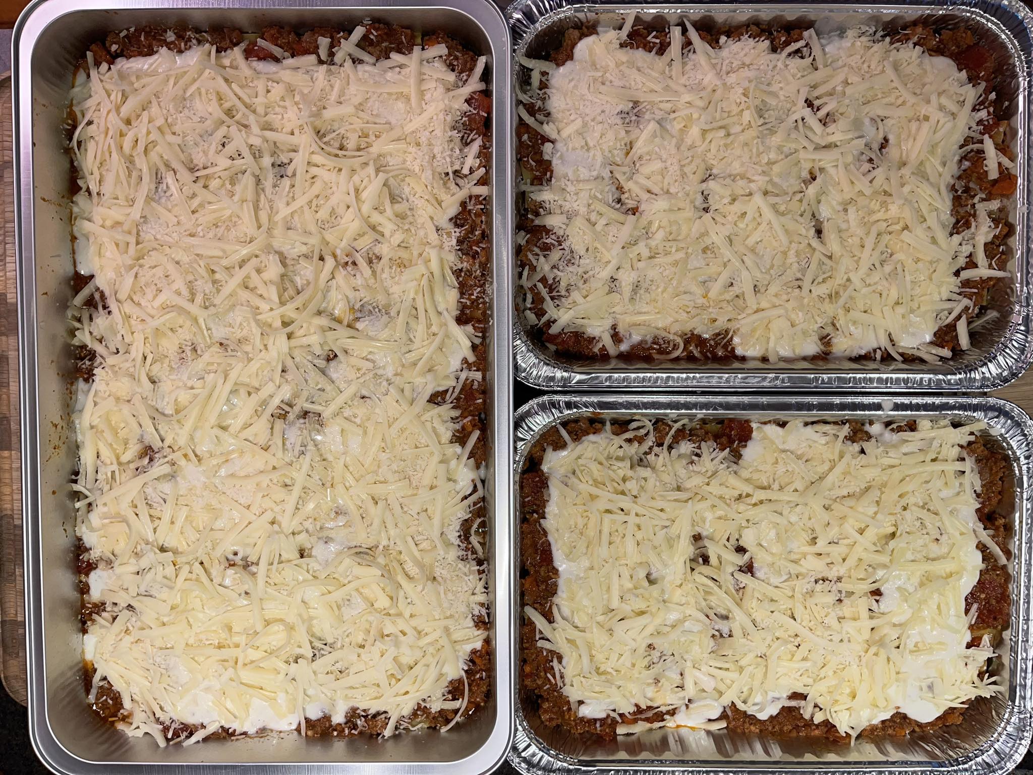 Lasagna Monster trays — large and medium sizes loaded with cheese